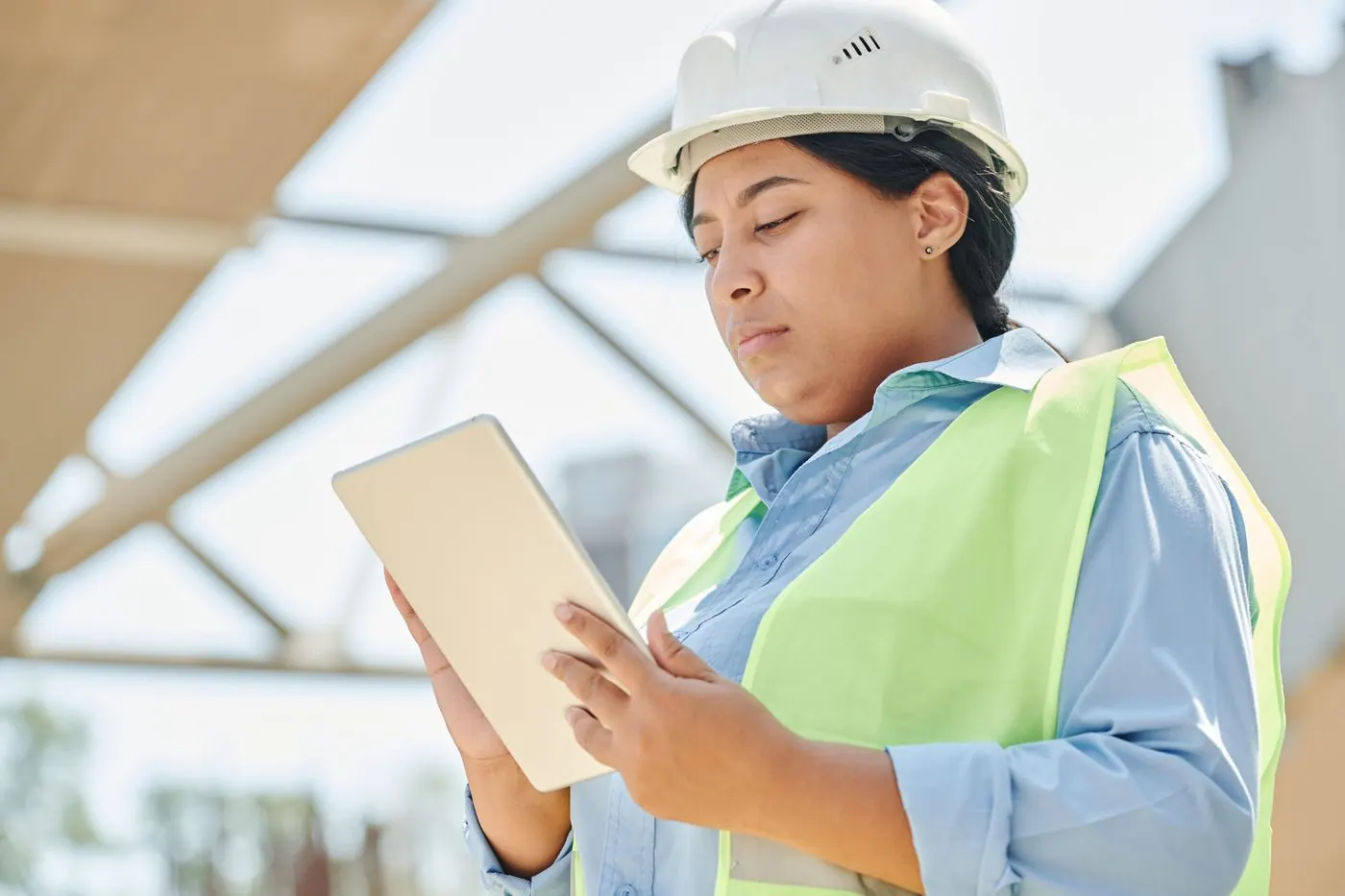 Engineer in hard hat using a tablet at a construction site